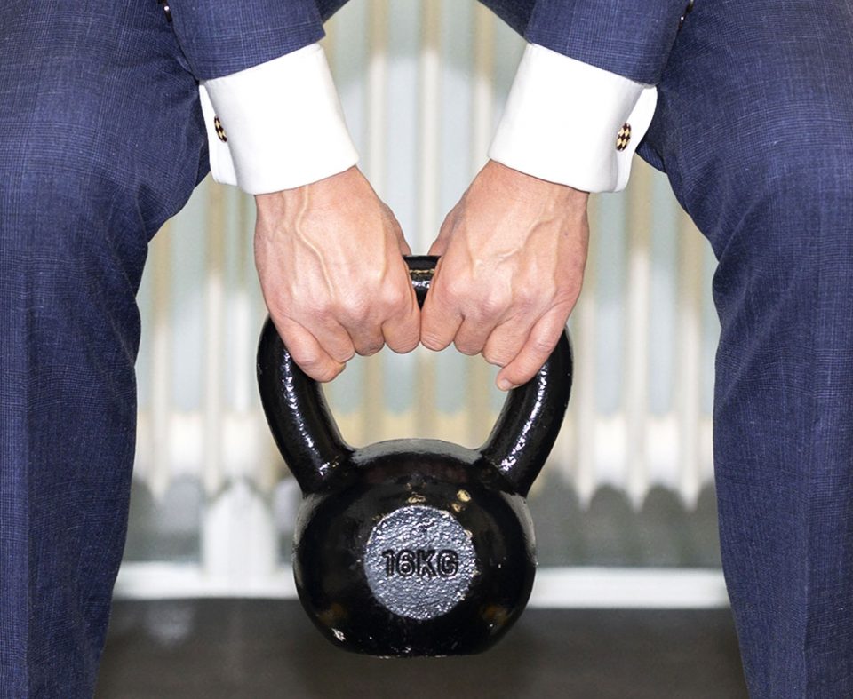 man in suit lifting weight